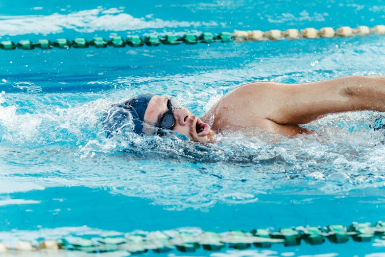 Man doing freestyle in a pool.