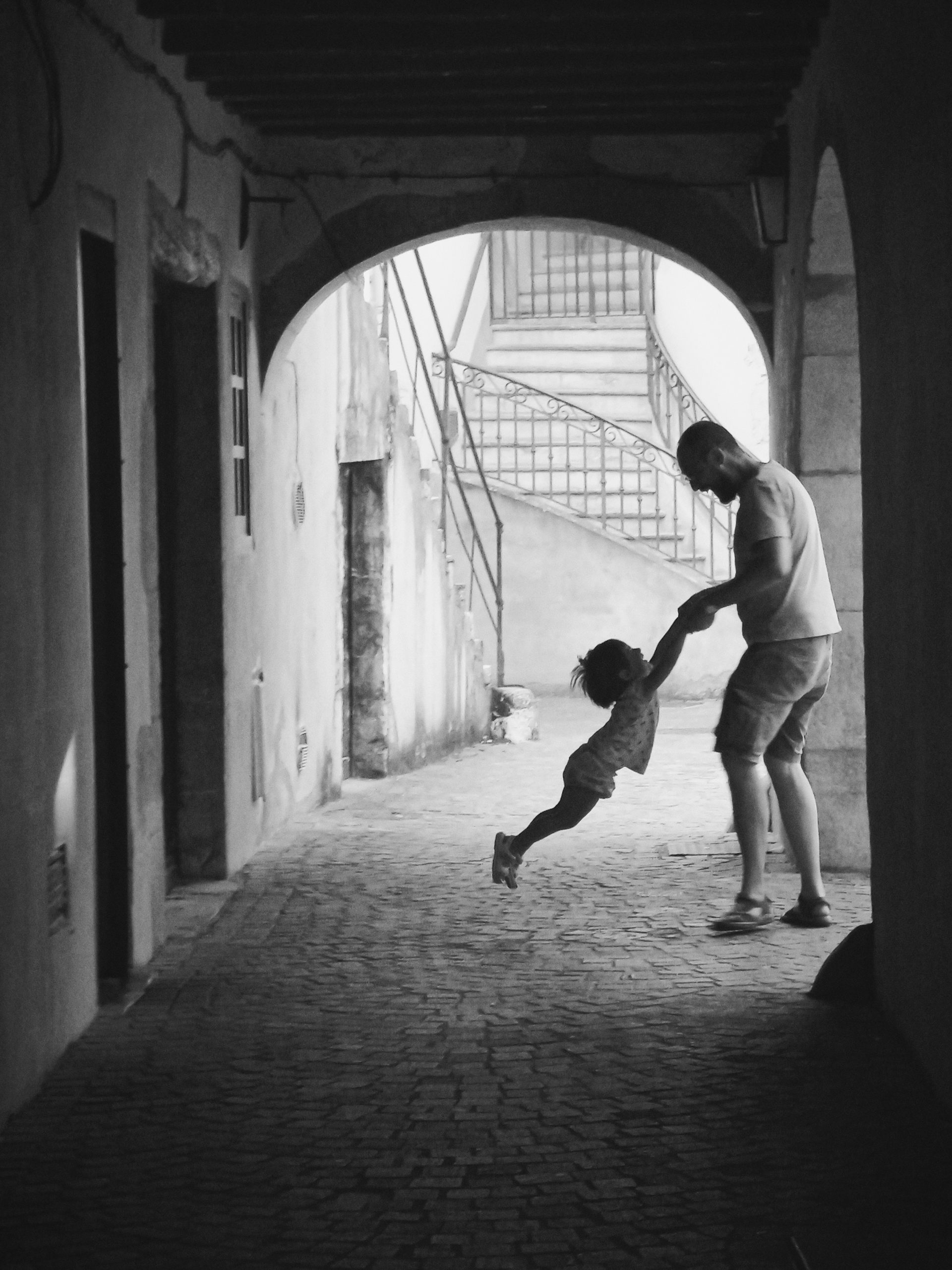 Father swinging a child in the air.