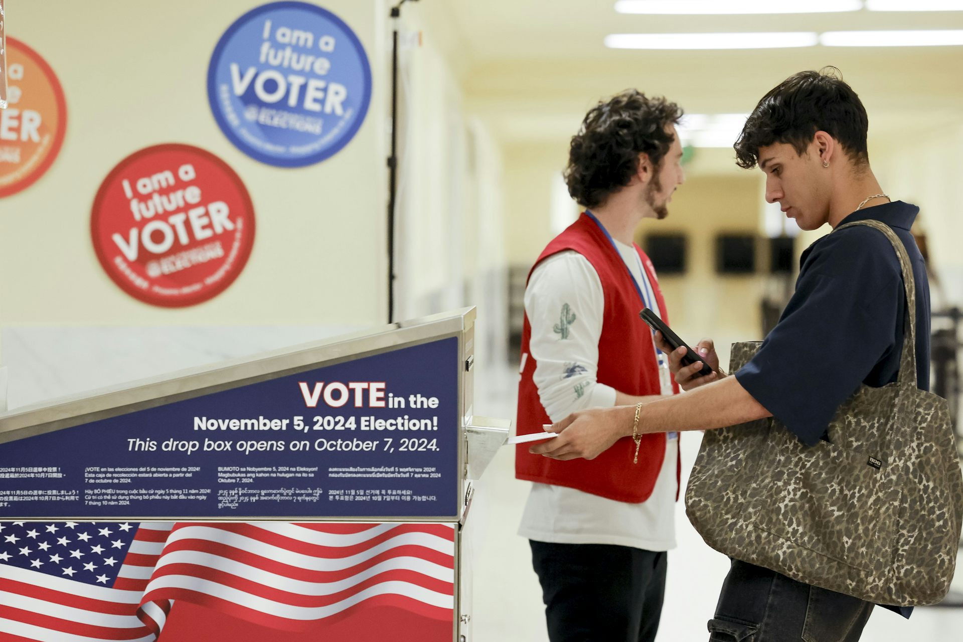 Two young men at a voting booth for the US 2024 presidential election.