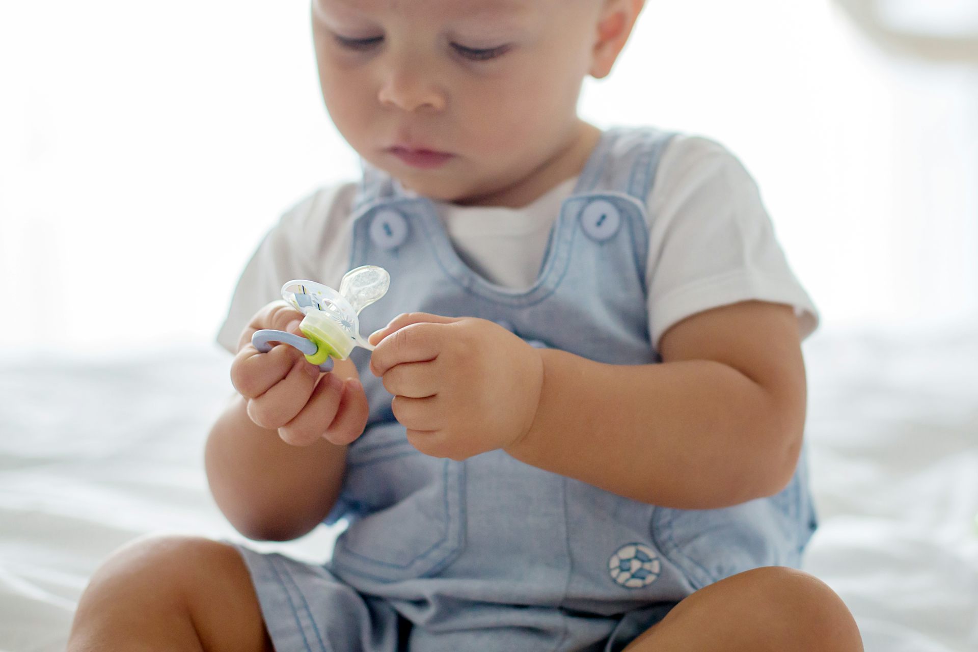 Un bebé mira un chupete.