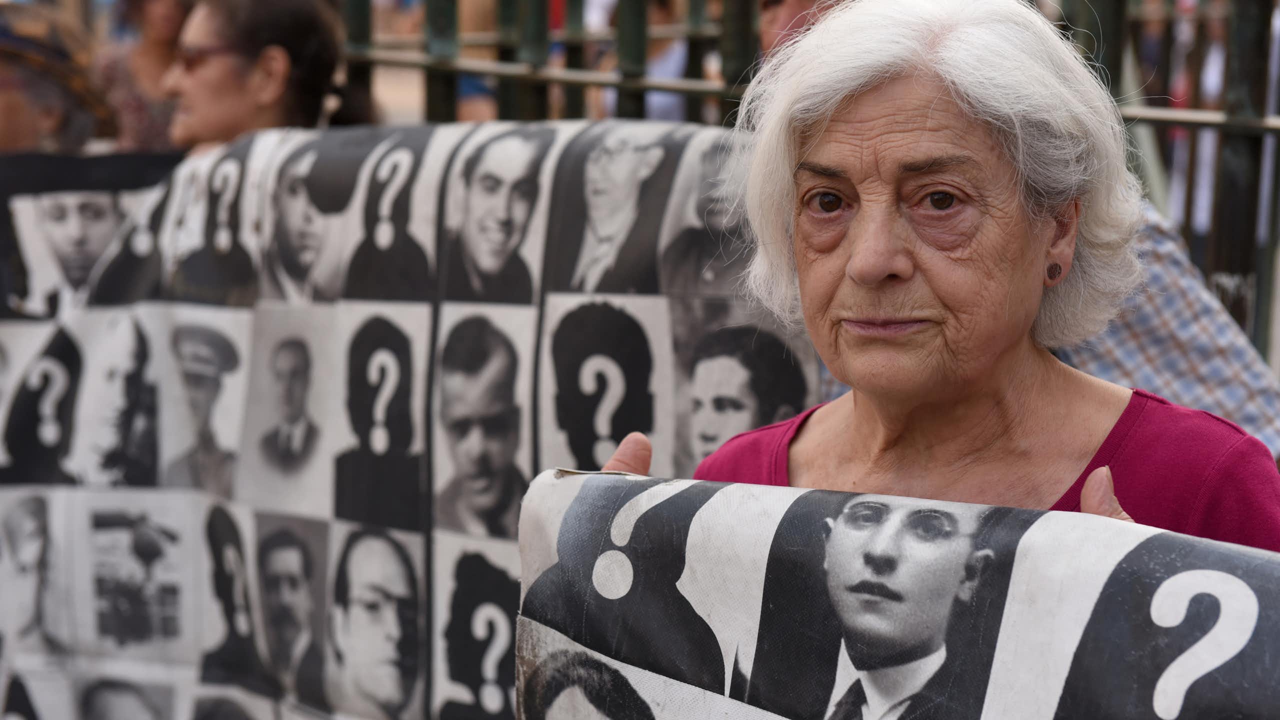 A woman holds a sign at a protest.