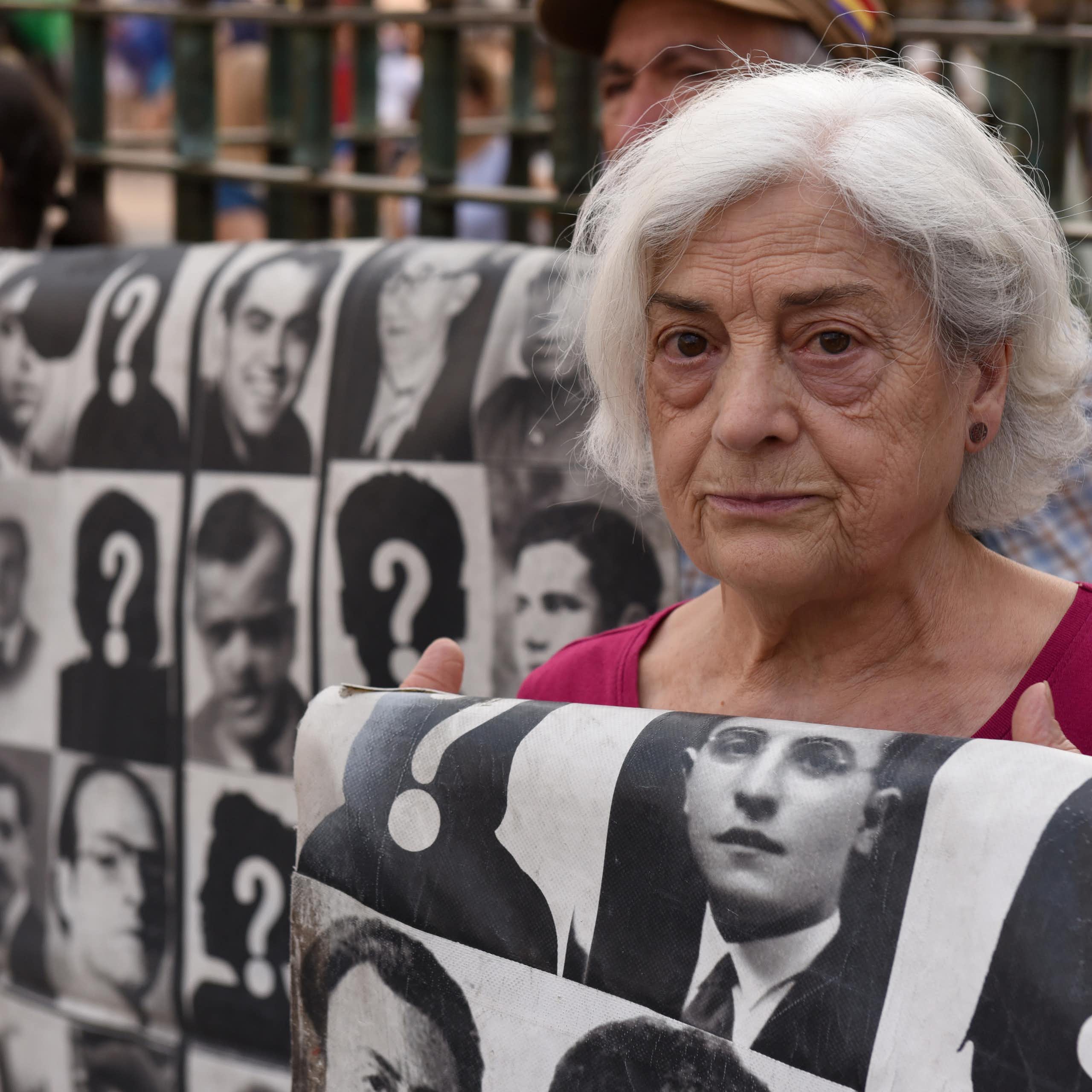 A woman holds a sign at a protest.