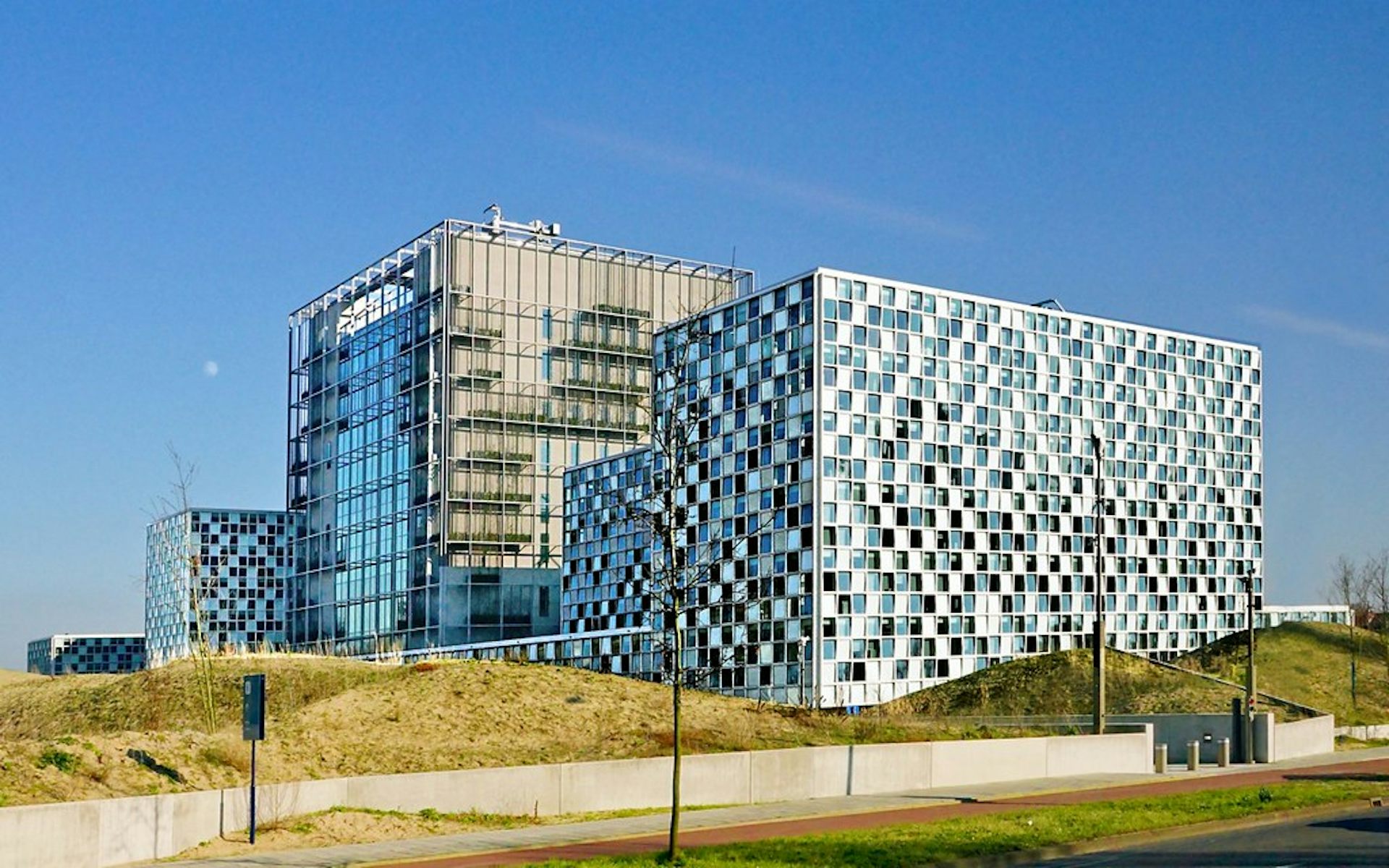 A complex of buildings from a distance, including one with many small square panes of glass.
