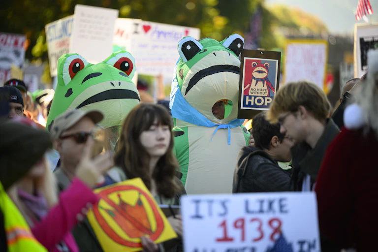 Protesters wearing frog costumes in a crowd of people.