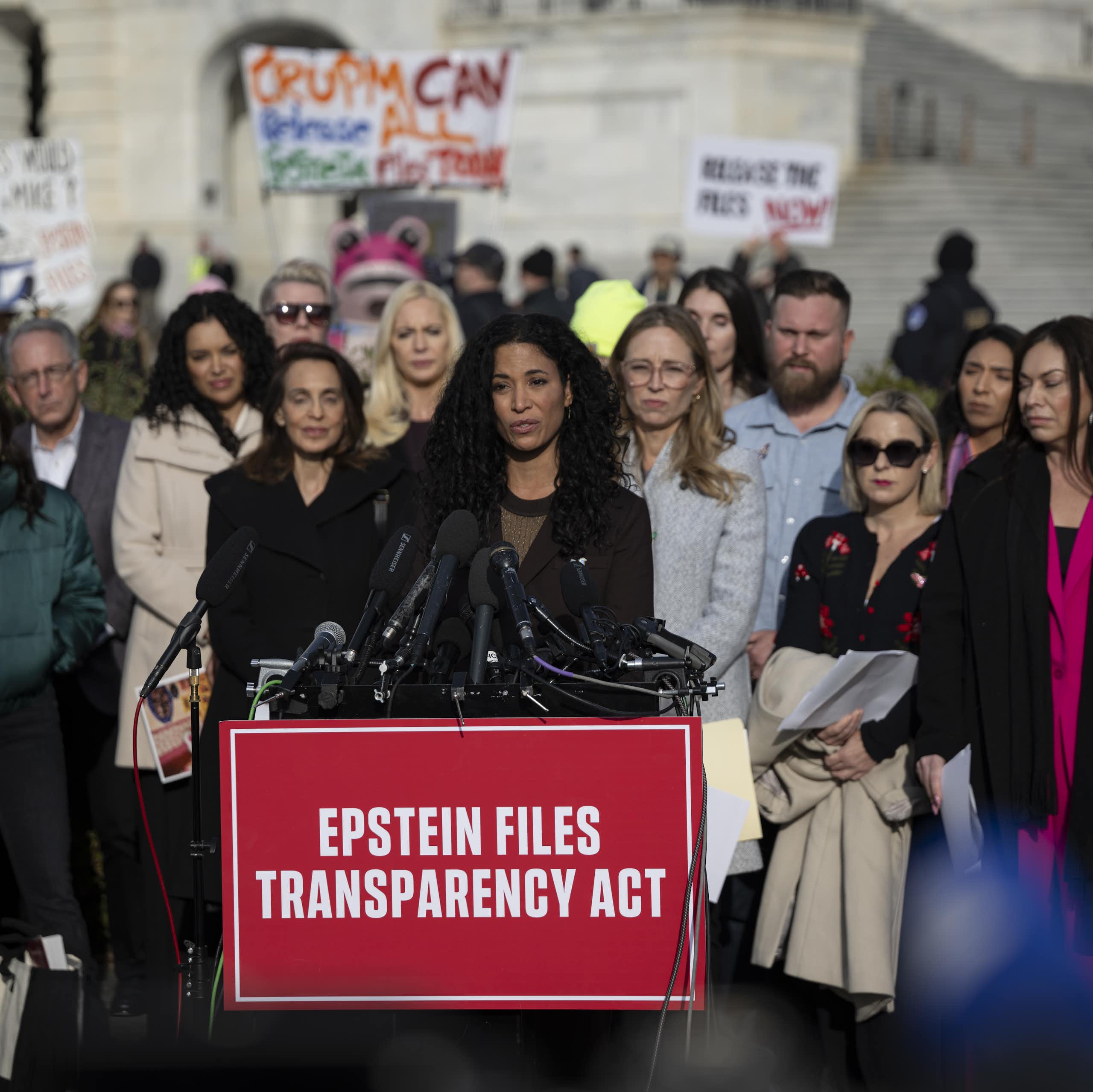 A woman speaks in front of a lectern outdoors.