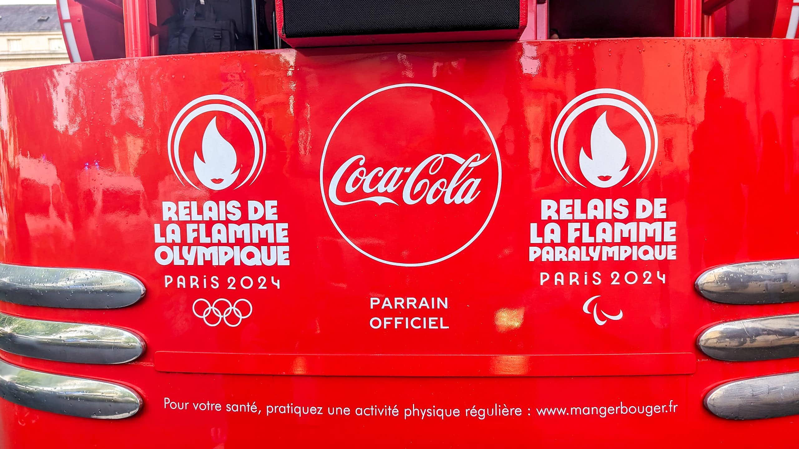 Devanture d'un camion des Jeux Olympiques avec le logo de Coca-Cola.