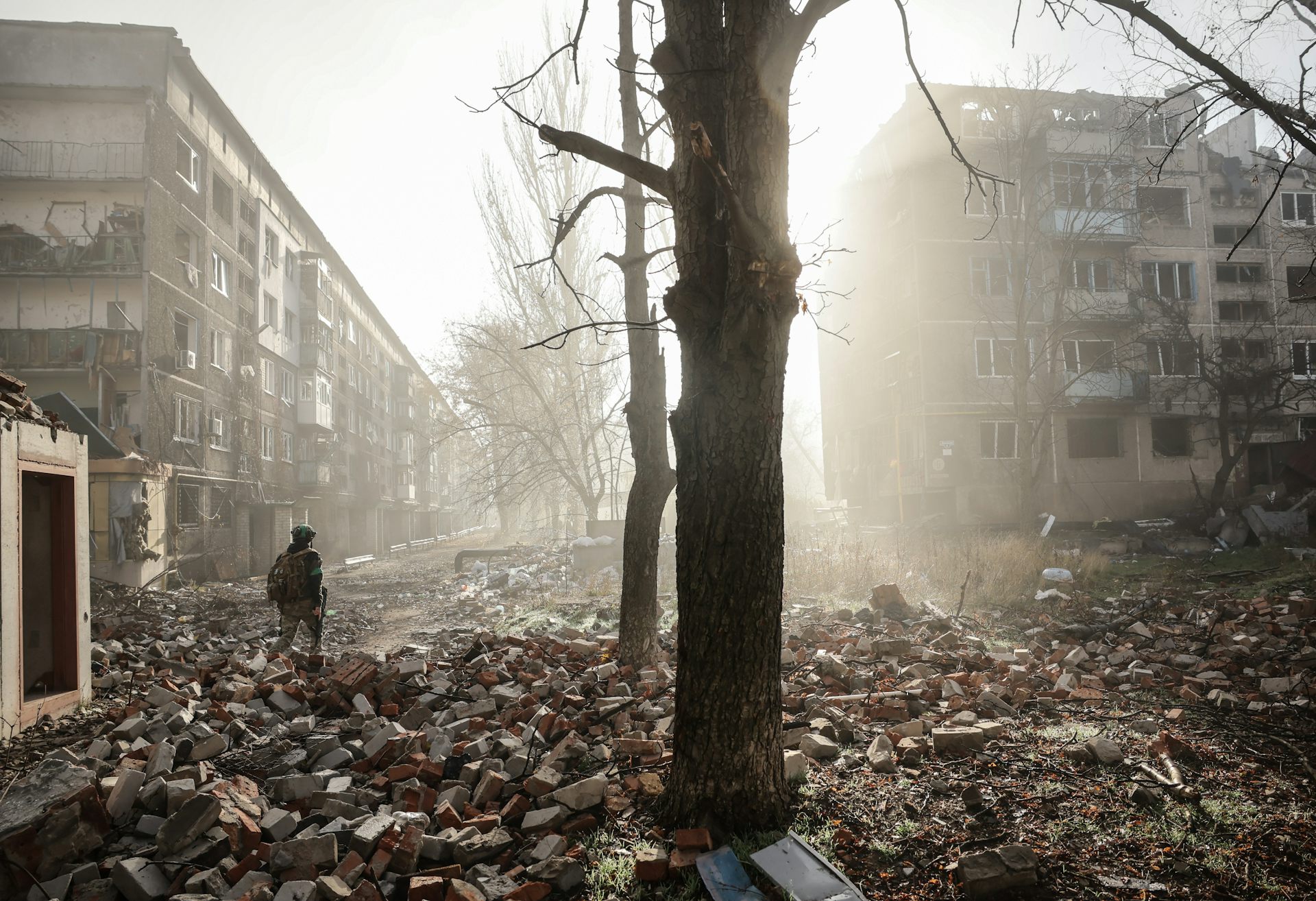 Ukrainian servicemen walk along a road in a badly damaged frontline city.