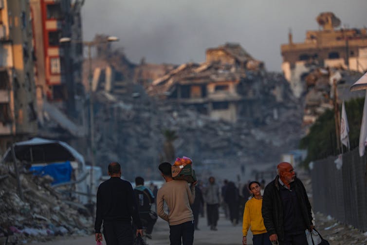 Are issues falling aside for Ukraine? 1 Palestinians walk among the rubble of destroyed buildings.