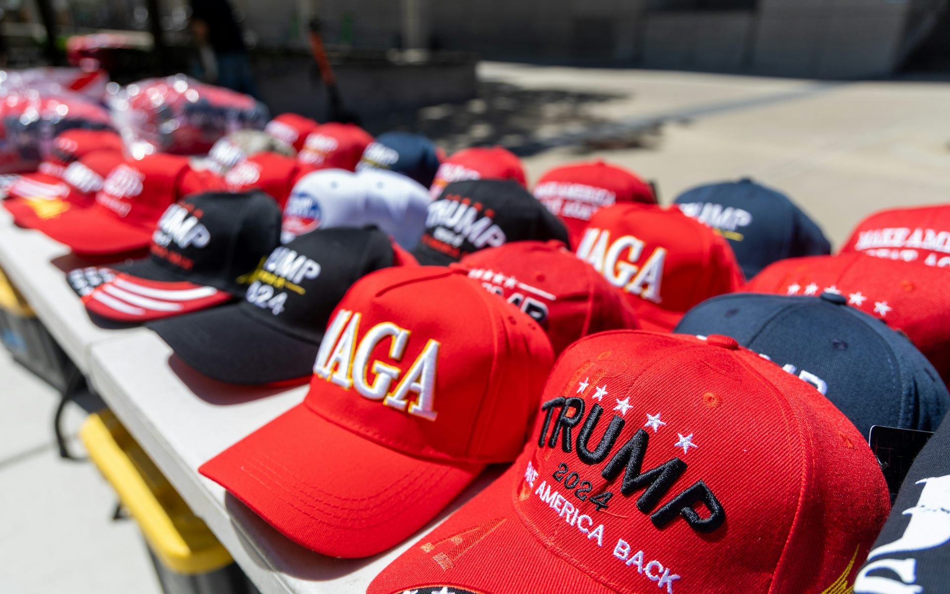 Un assortiment de casquettes siglées MAGA (Make America Great Again) et Trump, en vente lors d'un rassemblement à Detroit en juin 2024.