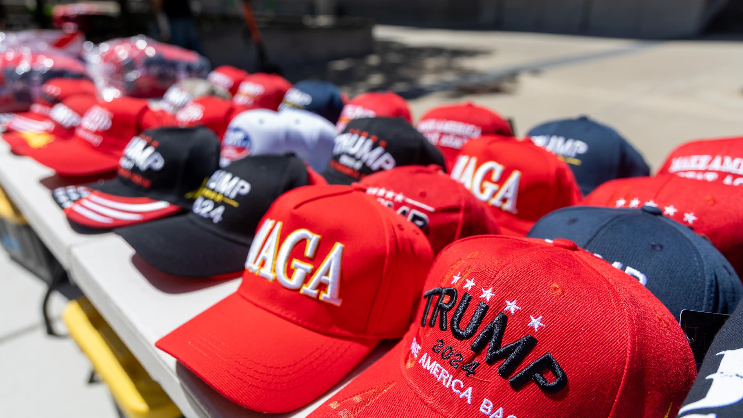 Un assortiment de casquettes siglées MAGA (Make America Great Again) et Trump, en vente lors d'un rassemblement à Detroit en juin 2024.