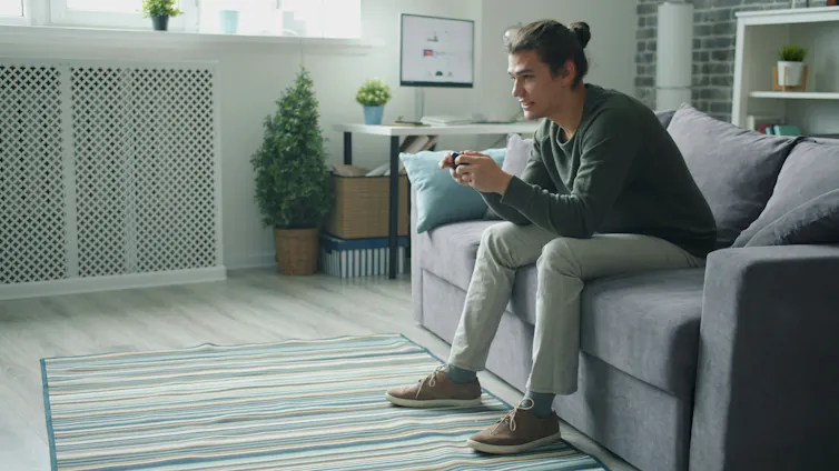 Jeune adulte jouant à un jeu vidéo