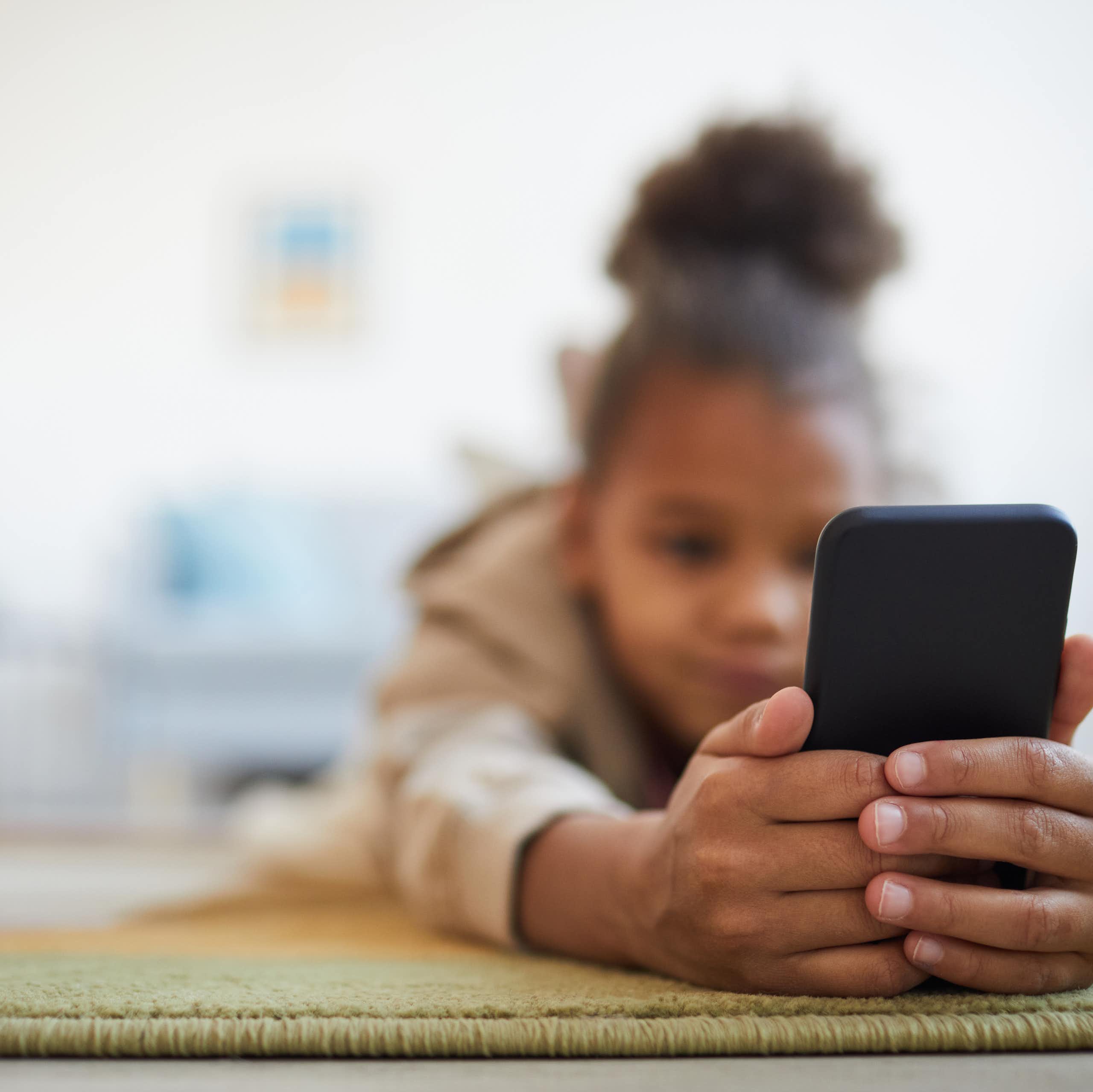 Une adolescente en train de regarder son téléphone portable.
