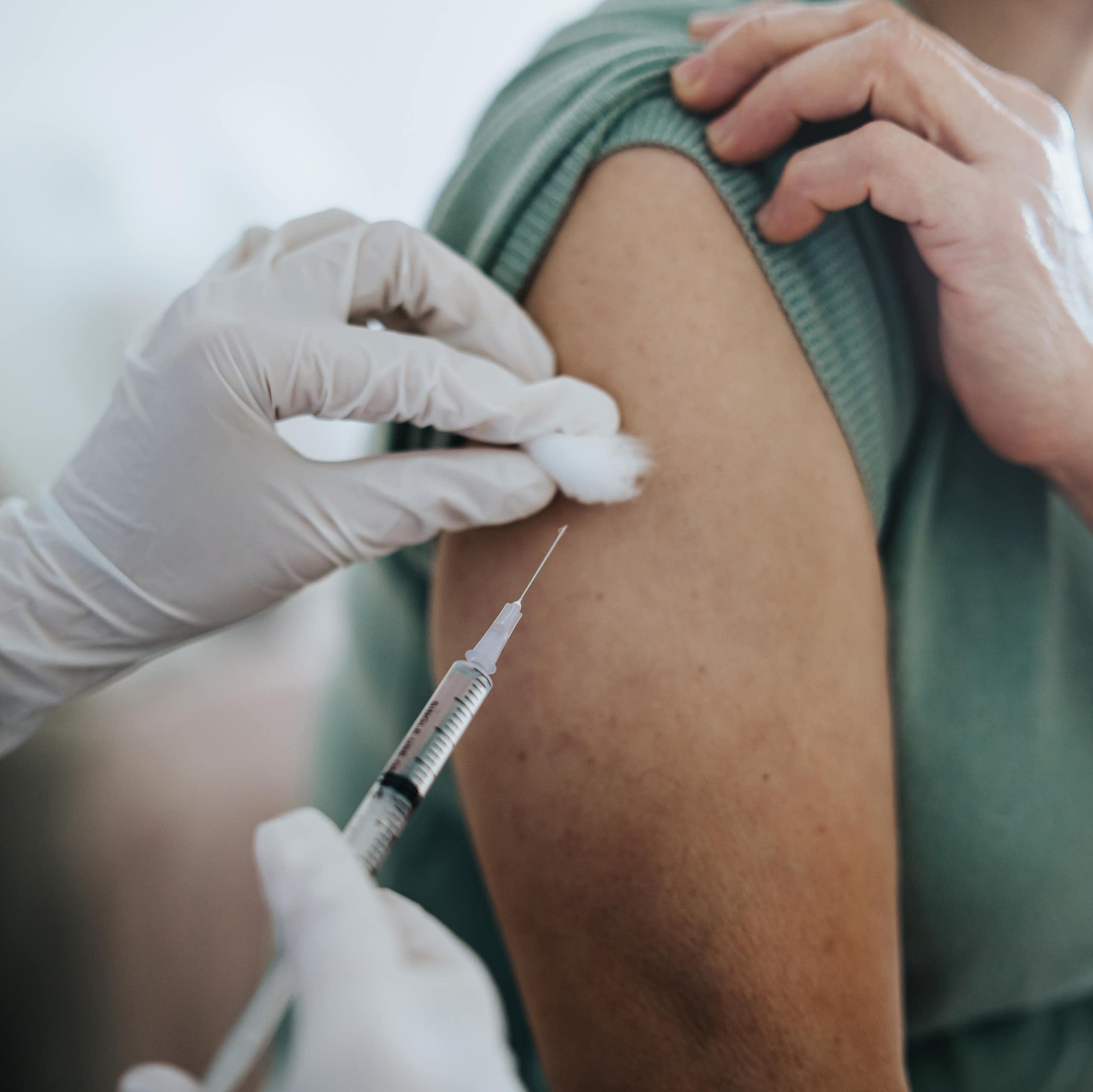 Close-up of someone getting a shot in their arm.