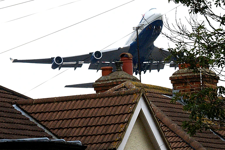 A British Airways Jumbo jet takes off over a row of houses near London's Heathrow airport