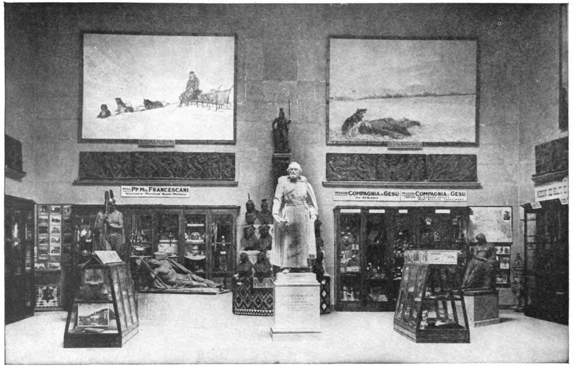 Statue on a pedestal surrounded by images on walls and some items in cases. 