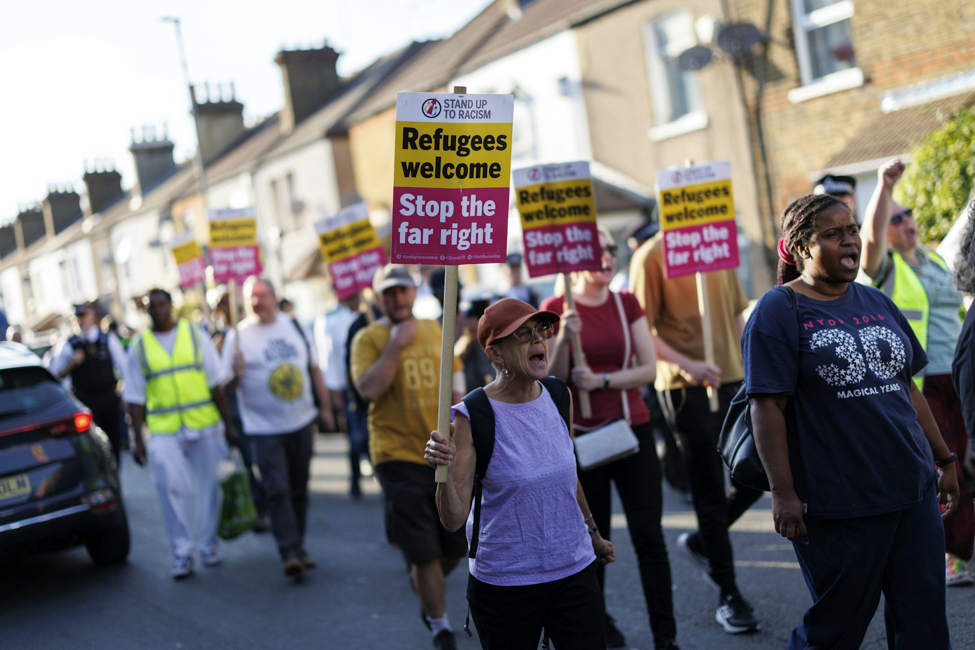 Counter-protesters with signs reading 'refugees welcome, stop the far right'
