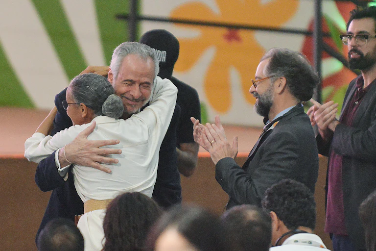 man and woman embrace at climate talks.