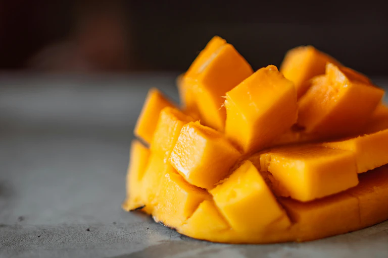 Mango cheek cut into a hedgehog on grey surface