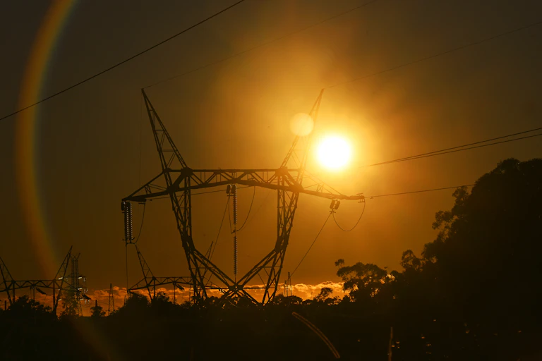 high voltage transmission lines with sunset behind.