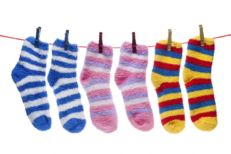 Striped fuzzy socks hanging on a clothes line