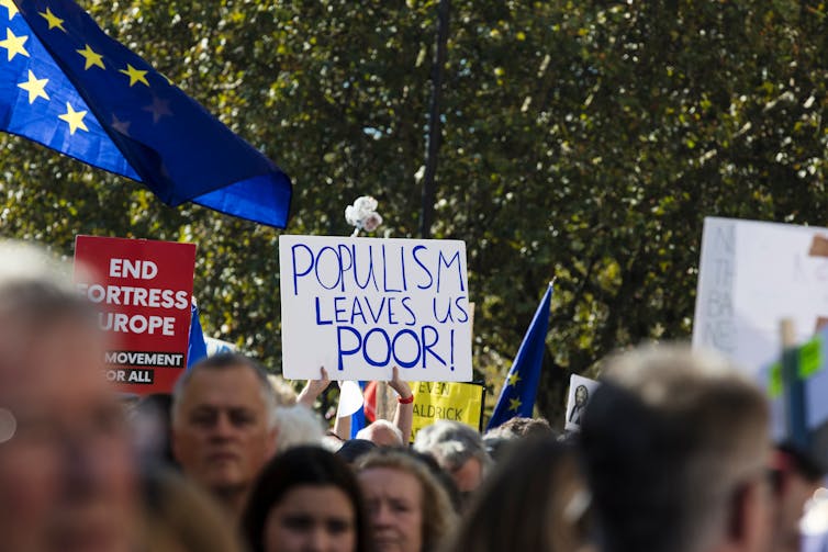 anti-brexit protesters waving a placard reading populism leaves us poor.