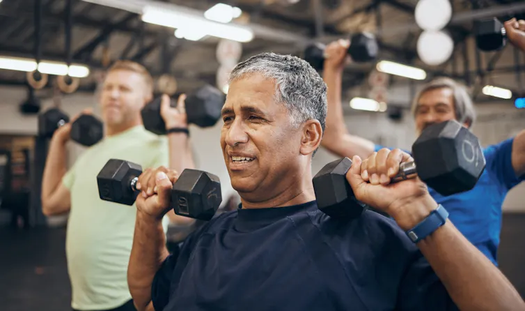 Man struggling to lift dumbbells.