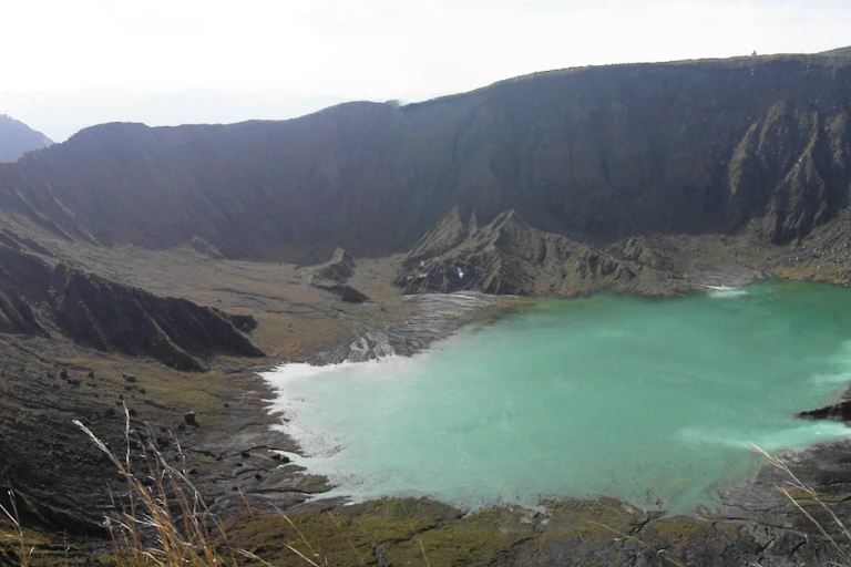 volcano, blue lake on top of mountain, grey sky