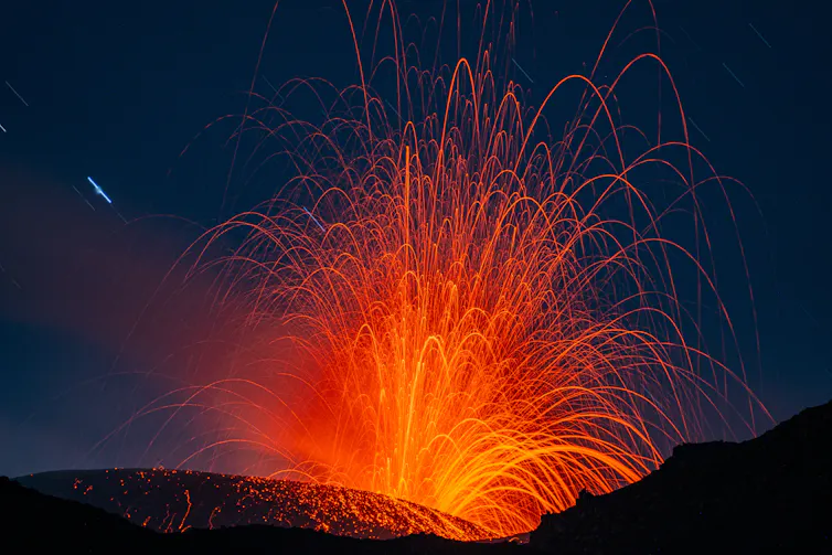 volcano erupting with red explosive ash