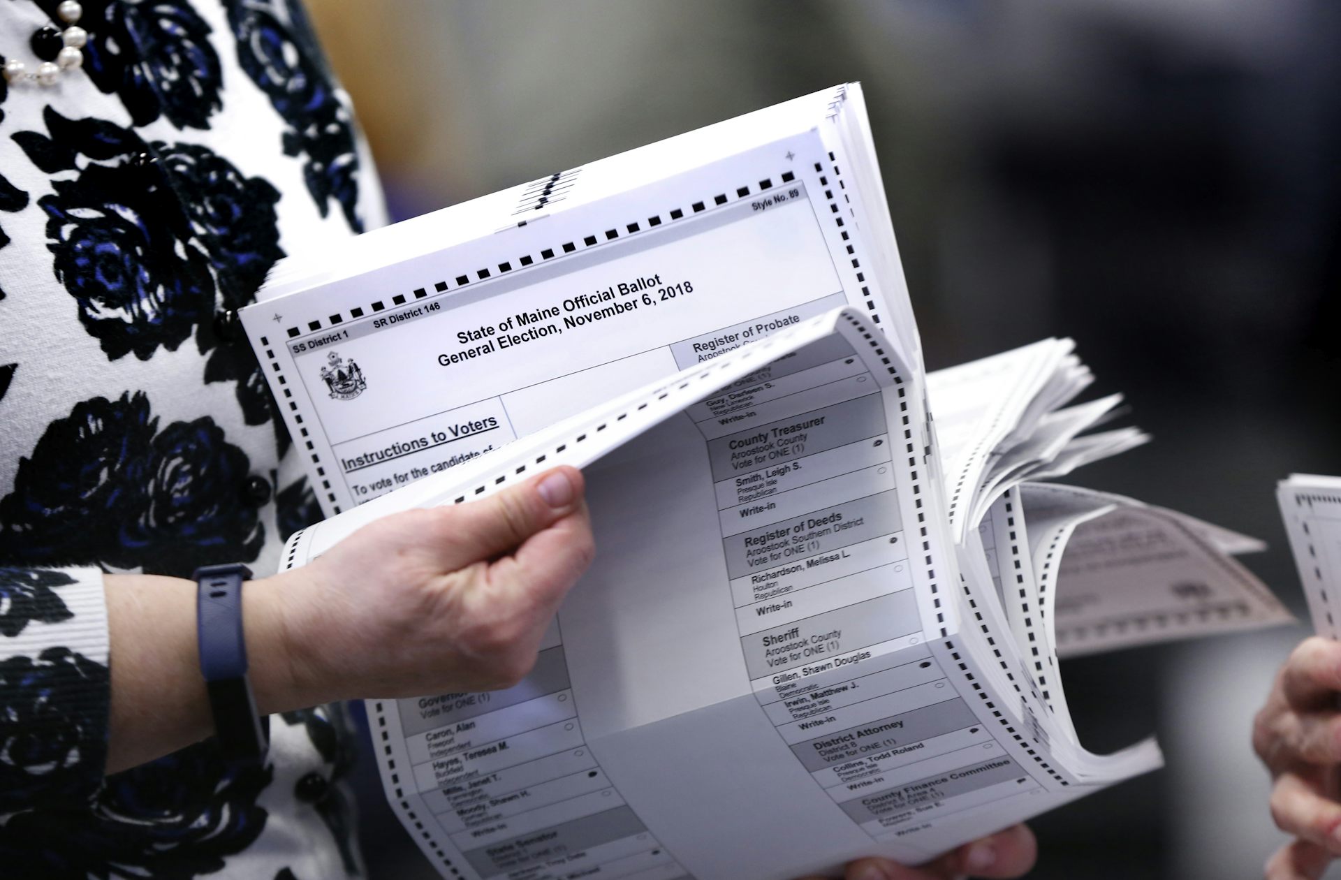A person flips through tabulated ballots.
