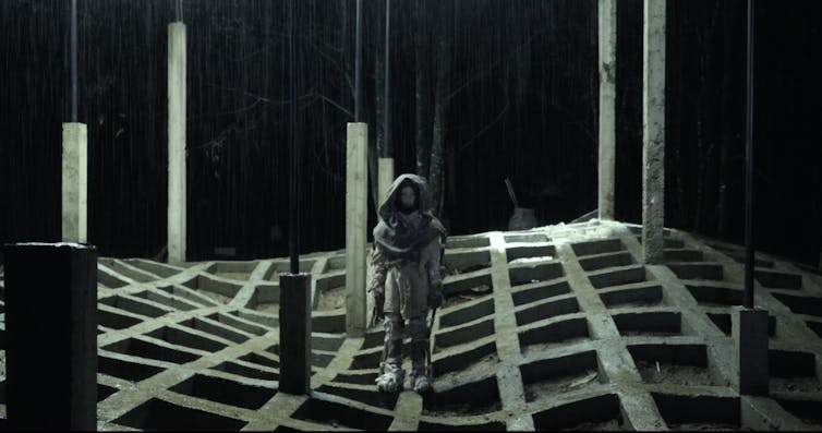 A figure stands in an otherworldly landscape.