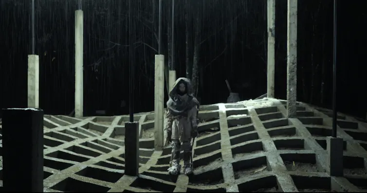 A figure stands in an otherworldly landscape.