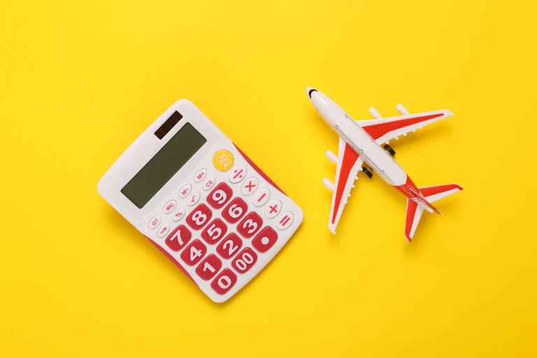 toy white and pink calculator and toy plane on bright yellow background