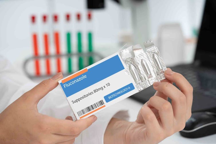 A person holds a box of fluconazole, the medicine used to treat thrush.
