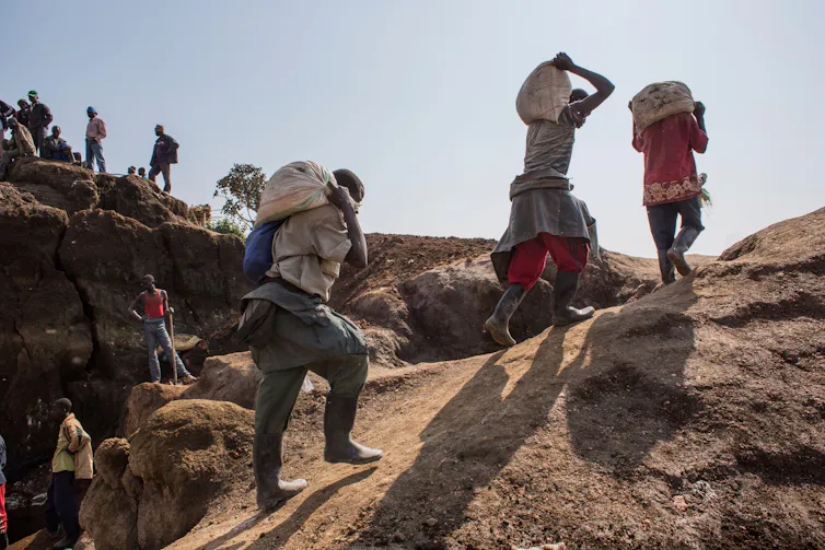 Miners carry sacks