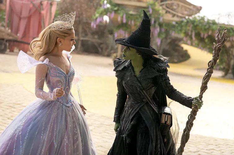 A white witch and a green witch involved in a tense discussion.