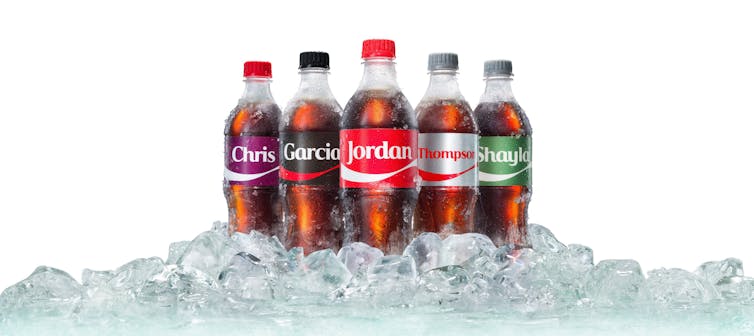 Five soft drink bottles, each featuring labels with a different name.