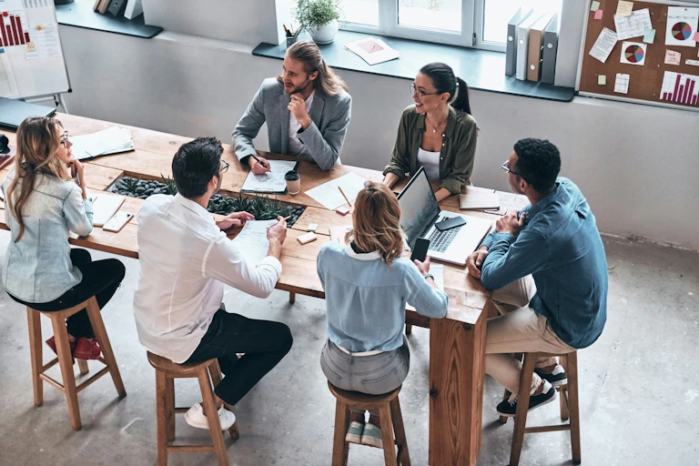 A group of people sitting around a table in an office