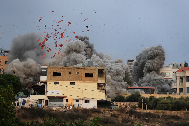 A still image shows debris and smoke from an airstrike.