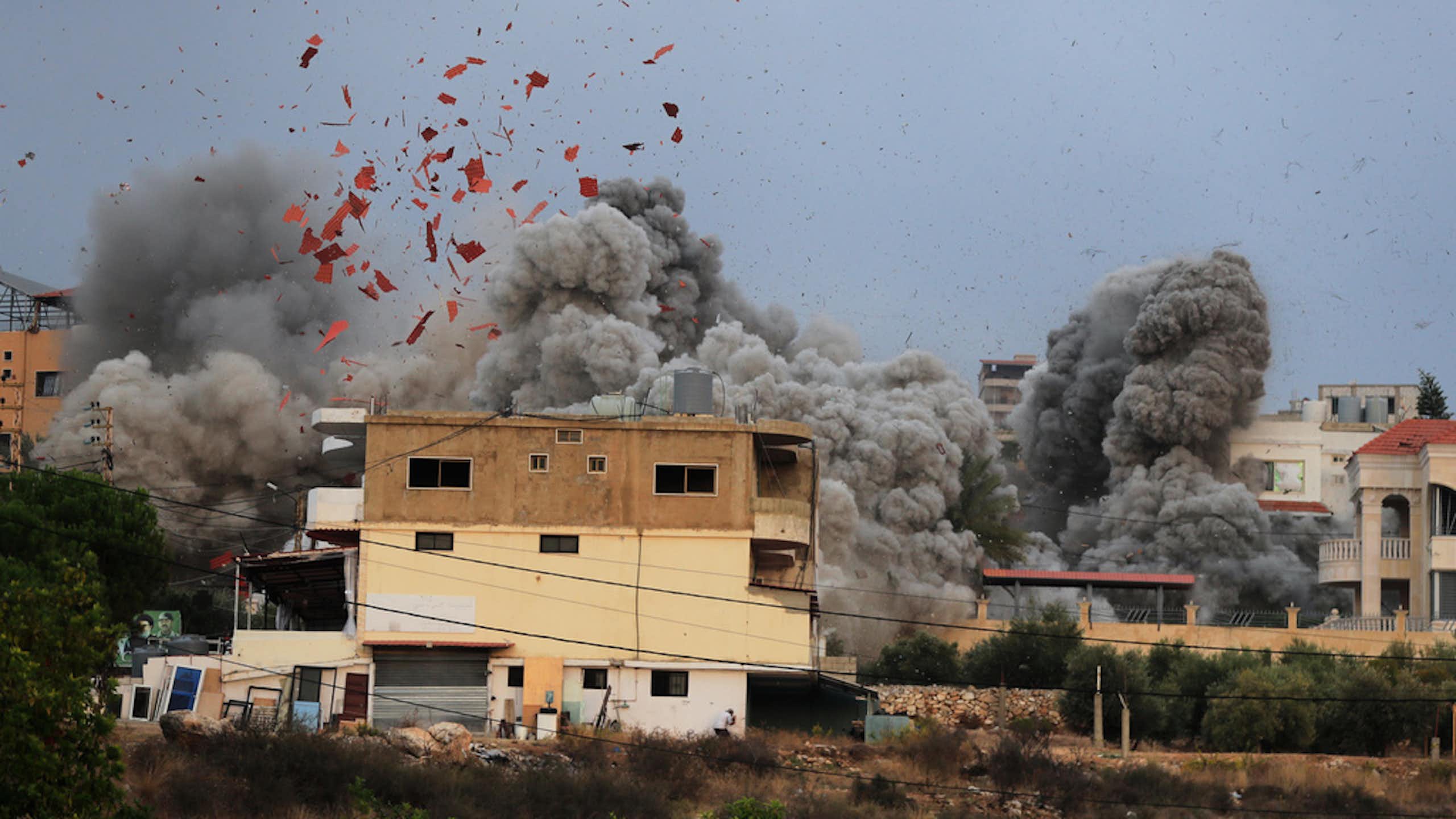 A still image shows debris and smoke from an airstrike.