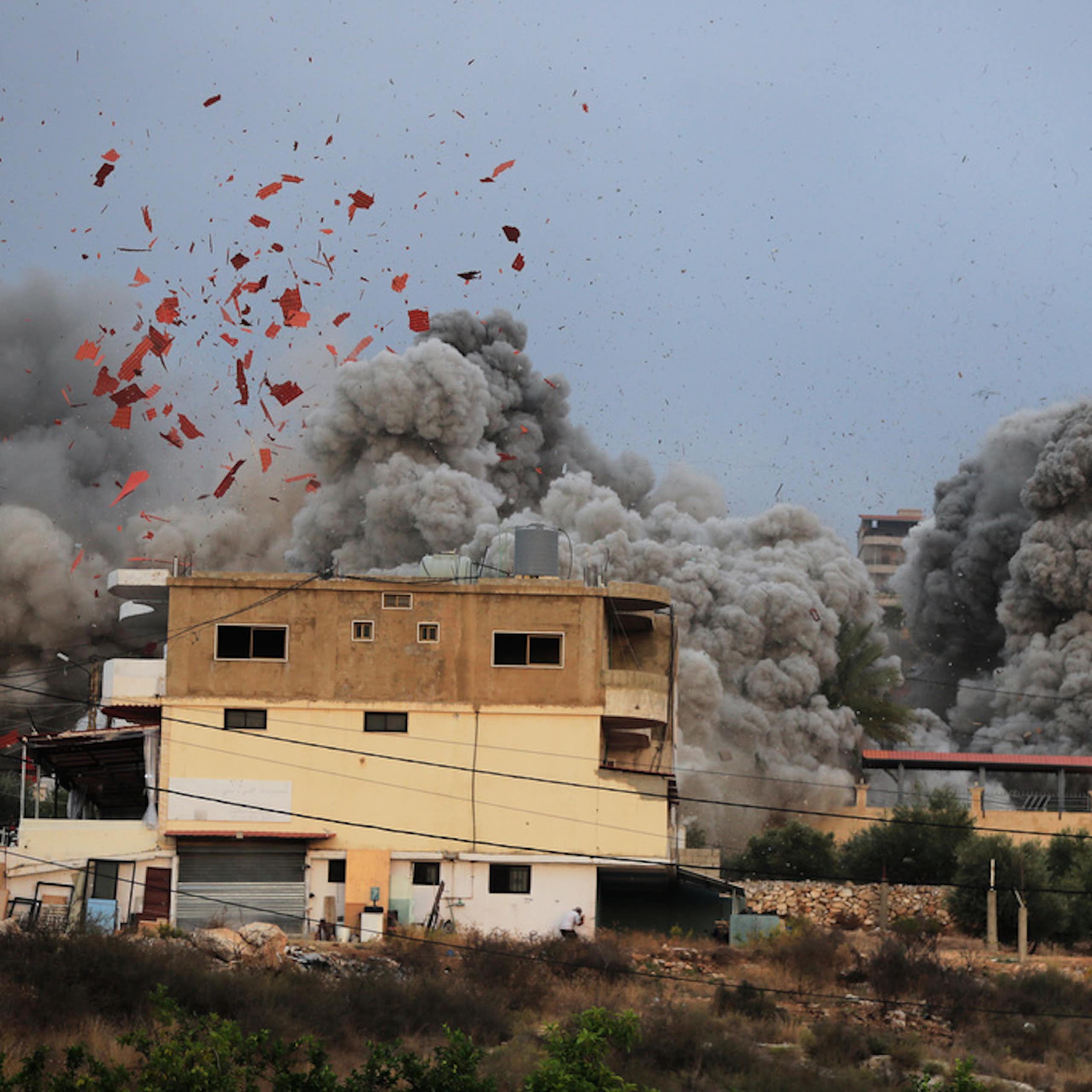 A still image shows debris and smoke from an airstrike.