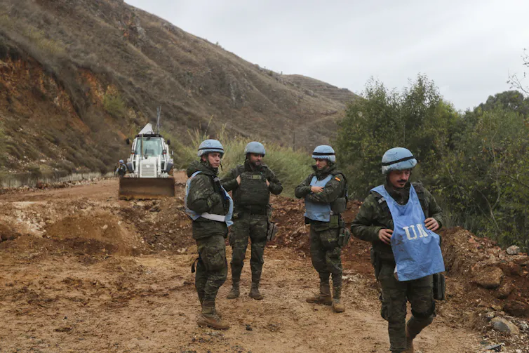 Soldiers with helmets on a patrol.