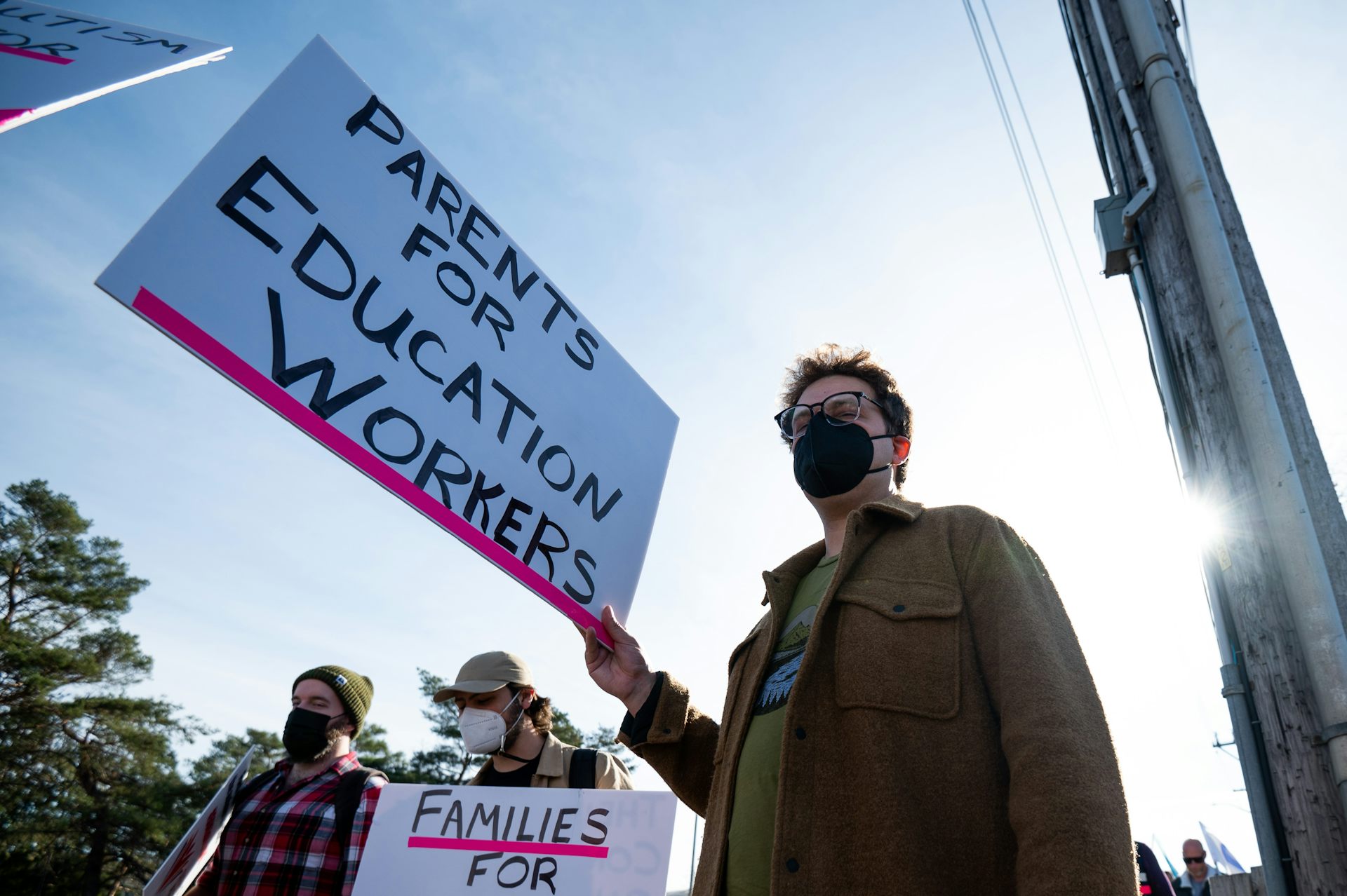 A person with a placard that says parents for education workers.