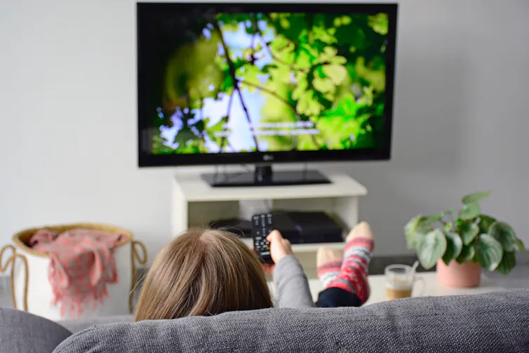 Woman watching TV with subtitles on