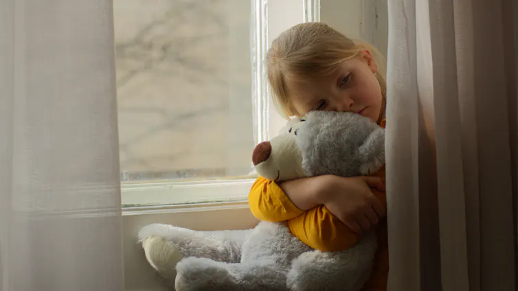 Sad girl hugging teddy