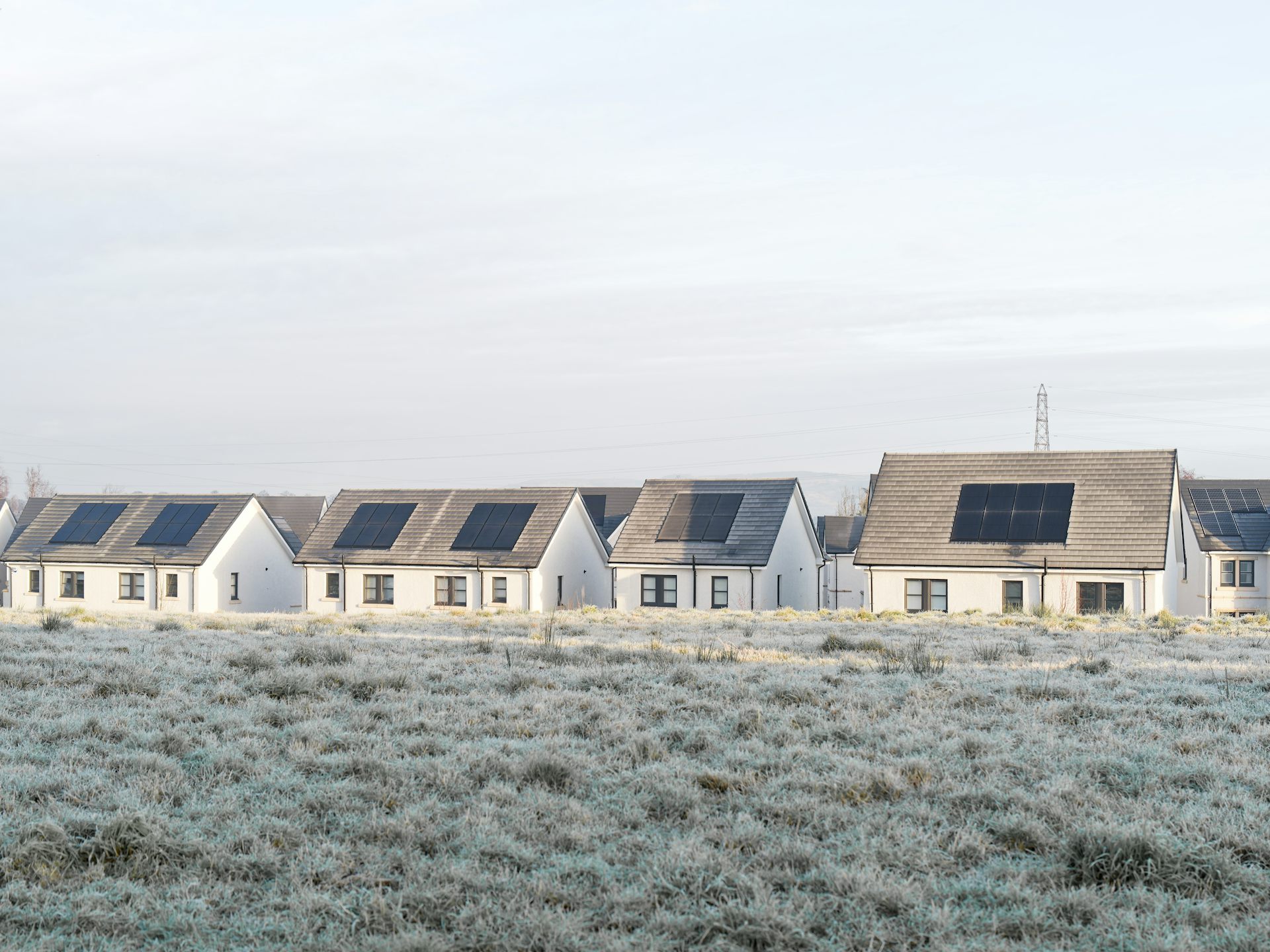Homes with solar panels on frosty day.
