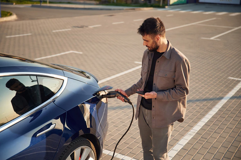 Man charging electric car.