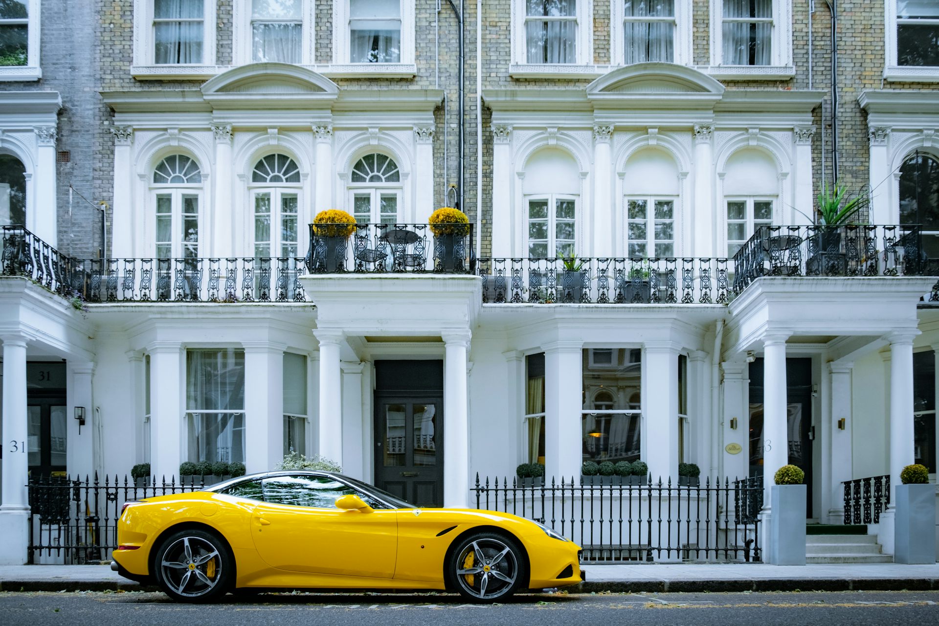 Yellow Ferrari parked outside London houses.