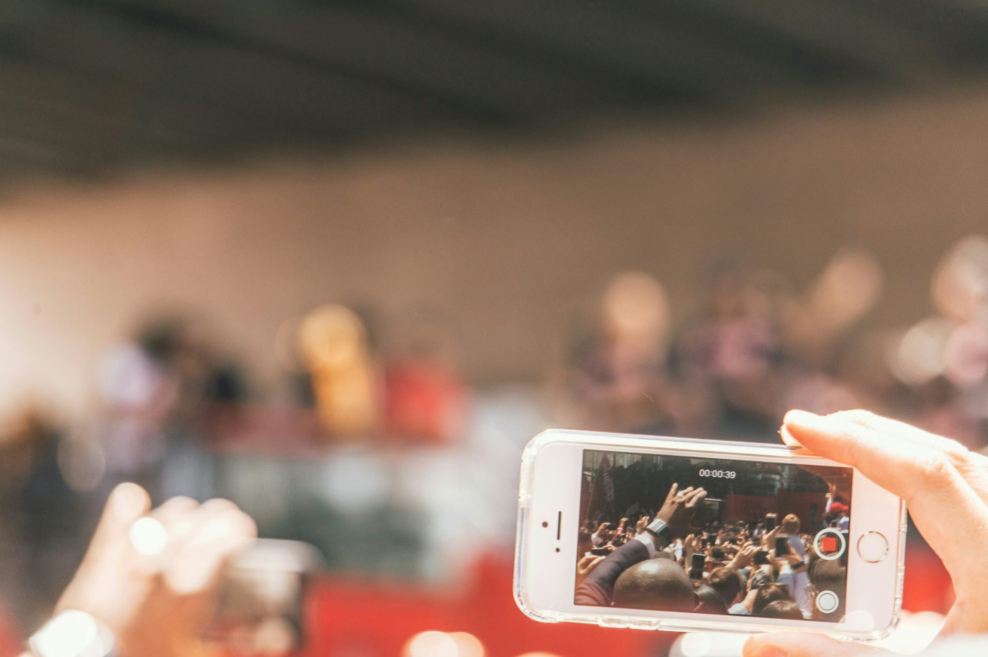 Une personne filme une foule avec son téléphone portable