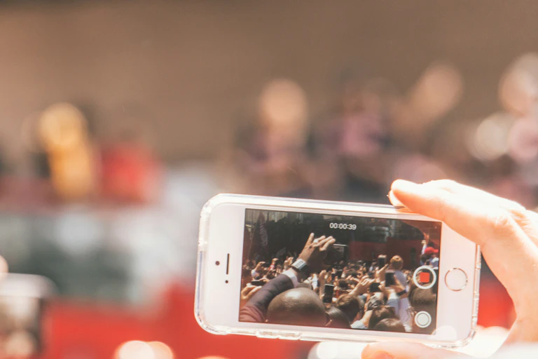Une personne filme une foule avec son téléphone portable