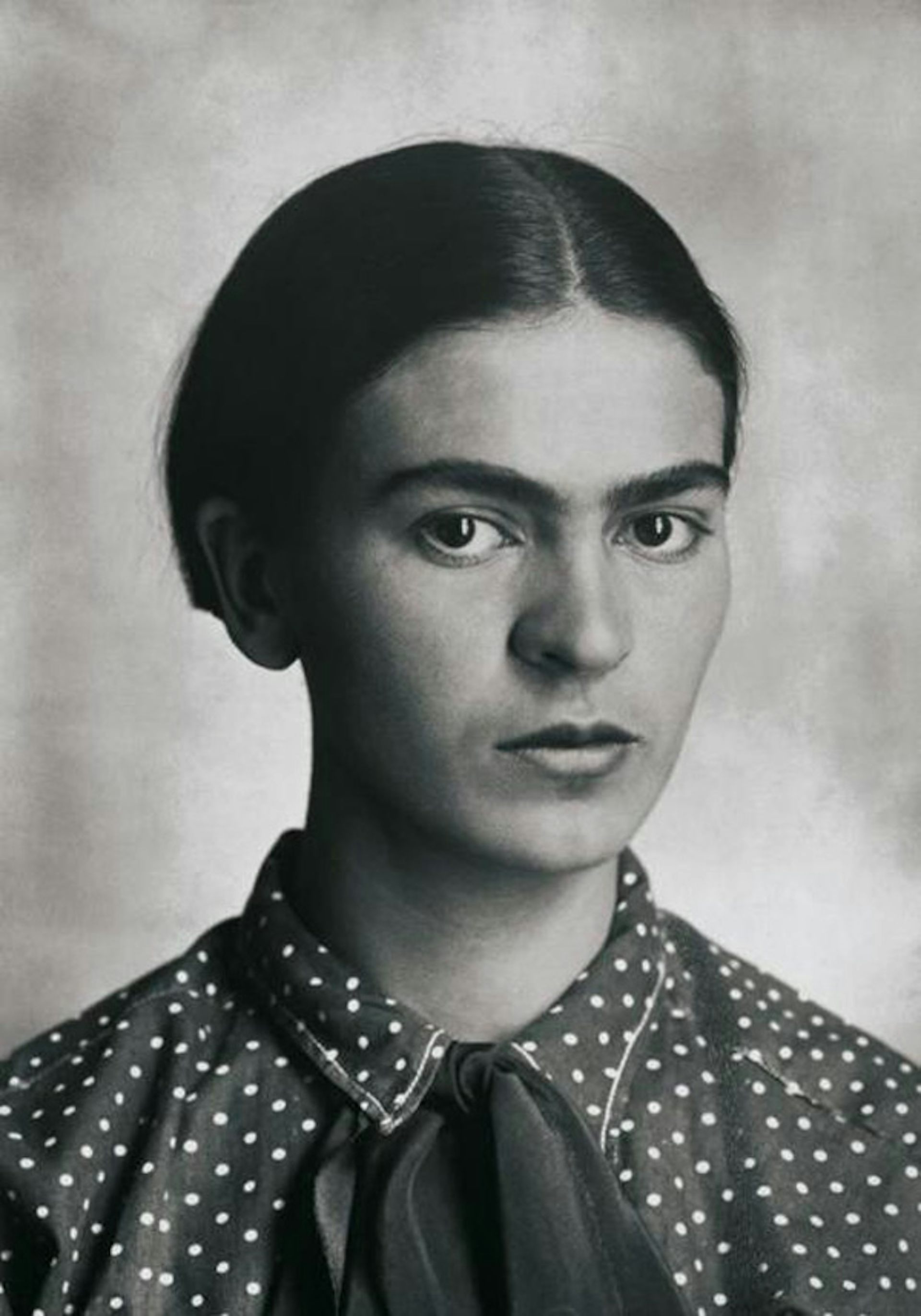 a young Frida Kahlo with hair smoothed back in a centre parting